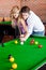 Kind boyfriend teaching pool to his girlfriend