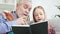 Kind grandpa reading interesting book with granddaughter