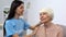 Kind volunteer combing aged woman hair, old patient care, smiling each other