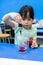 Kindergarten girl using droplet to add red color into a cup on b