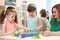 Kindergarten teacher and children playing toy sorter in daycare centre