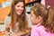 Kindergarten teacher speaks to a girl in daycare