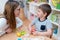 Kindergarten Teacher Supports Cute Boy in Educational Game Play