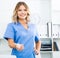 Kindly woman in doctor`s uniform greets visitors at modern office