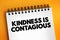 Kindness Is Contagious text on notepad, concept background