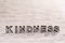 Kindness word on white sand