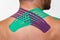 Kinesiology taping.Close up view of kinesiology tape on patient neck.Young male athlete on white background.Post