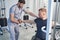 Kinesitherapy exercise. Doctor treat wheelchair man with shoulder pain