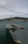 Kinetic sculpture of Eater Whirler on coastal deck with stairs and catwalk, and city on island across bay, Wellington, New Zealand