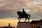 King Ferdinand I statue at dusk under an orange sky in Oradea, Romania