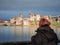King John`s stone castle with tall walls and towers on river Shannon in focus. Teenager girl looking at the scene out of focus.