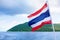The Kingdom of Thailand flag, sea, sky, island beautiful landscape background, flag on pole waving on wind, state symbol