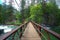 Kings Canyon wooden footbridge over fast flowing river in the Sierra Nevada mountains, California