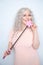 Kinky pretty woman with pink star riding crop. cute blonde woman holds bdsm whip on white solid studio background.