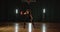 Kinky young caucasian basketball player dribbling training ball tricks neon light background