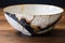 kintsugi repaired ceramic bowl on wooden surface