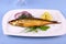 Kippers, smoked herring on a white plate with garnish