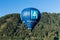 Kirchberg in Tirol, Tirol/Austria - September 27 2018: A blue AlpenBank sponsored hot-air balloon flying over forested hills in