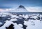Kirkjufell mountain, Iceland. Winter landscape. The mountain and the ocean. Snow and ice.