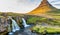 Kirkjufell Waterfalls and Mountain at sunset, wide angle view on a sunny summer day