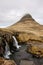 Kirkjufellsfoss waterfall, Kirkjufell mountain, raincloud, hayfield, Iceland