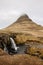 Kirkjufellsfoss waterfall, Kirkjufell mountain, raincloud, hayfield, Iceland