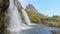Kirkjufellsfoss waterfall near the Kirkjufell mountain, unrecognisable woman