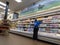 Kirkland, WA USA - circa March 2022: Angled view of an adult woman worker inside a Trader Joe`s grocery store, restocking the