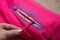 Kirov, Russia - January 16, 2023: Ski jacket sleeve with zipper, logo and hand. Pink beautiful ski jacket photographed