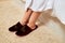 Kirov, Russia - March 16, 2019: Close up crimson slippers on woman`s legs standing on carpet