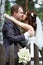 Kiss bride and groom about wooden fence