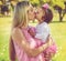 Kisses for my darling. a mother holding her adorable little girl while standing outside.