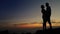 Kissing couple on the rocky coastline with great sunset sunrise sky