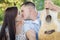 Kissing Mixed Race Couple Portrait with Guitar in Park