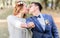 Kissing newlyweds reach out their fists with wedding rings