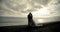 Kissing wedding couple stands against the sunset on a beach in Iceland.