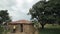 KISUMU,KENYA - MAY 15, 2018: Group of African children stands under tree near house, mom and children spend time