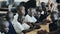 Kisumu,Kenya - May 15, 2018: Group of bald african children sitting. Boys and girls in uniform sing song and clap hands.