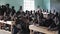 KISUMU,KENYA - MAY 21, 2018: Crowd of bald African children sitting at school desks. Boys and girls, teenagers in