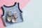 Kit of baby`s clothes on coloured background. Striped undershirt and tiny shoes for infant or toddler. Flat lay design.