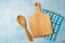 Kitchen background with cutting board, tablecloth and spoon over blue stone counter.