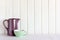 Kitchen background with jug and bowl. A shelf with dishes against a white wooden wall