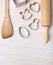 Kitchen bake utensils with easter cookie cutters on white wooden background, top view