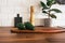 Kitchen brass utensils, chef accessories. Hanging kitchen with white tiles wall and wood tabletop.Green plant and avocado on