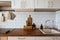 Kitchen brass utensils, chef accessories. Hanging kitchen with white tiles wall and wood tabletop.Kitchen background