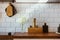 Kitchen brass utensils, chef accessories. Hanging kitchen with white tiles wall and wood tabletop.White flowers on