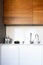 Kitchen brass utensils, chef accessories. Hanging modern kitchen with white marble wall and stone tabletop.