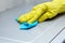 Kitchen cleaning.  female hand in a yellow rubber glove wipes the surface of the microwave oven from dust and dirt