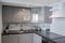 The kitchen corner in minimalistic design white and gray. Grey wooden facades, tiles, steel Utensils