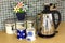 Kitchen counter with kettle and cups and flowers